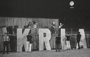 The Beatles on stage at Dodger Stadium behind the KRLA initials.